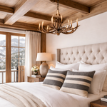 Cozy bedroom with a large bed, striped pillows, and a chandelier.