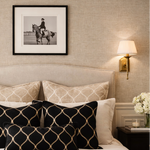 Neatly made bed with decorative pillows in a bedroom setting.